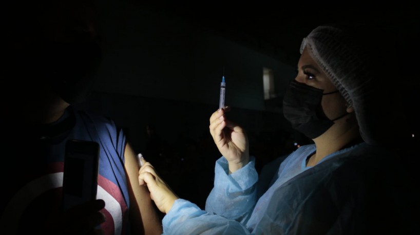  enfermeiros aplicam vacina no escuro durante oscilação de energia
